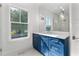 Bathroom with blue vanity, white countertop, and a large mirror at 1840 Biscayne Dr, Winter Park, FL 32789