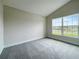 Bright bedroom with grey carpet, neutral walls, and a large window at 4376 Sagefield Dr, Harmony, FL 34773