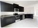 Modern kitchen with dark cabinets, granite countertops, and stainless steel appliances at 4376 Sagefield Dr, Harmony, FL 34773