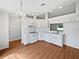 Bright kitchen featuring white cabinets, appliances, and hard wood floors at 7856 Habersham Dr, Lakeland, FL 33810