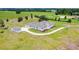 Expansive aerial view of a bright white, single-story home with a circular driveway, large lot, and separate storage shed at 9313 Quiet Ln, Winter Garden, FL 34787