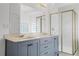Bathroom featuring double sinks, a large mirror and a glass enclosed shower at 9313 Quiet Ln, Winter Garden, FL 34787