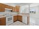 Efficient kitchen featuring wooden cabinets, white appliances, and tile floors at 9313 Quiet Ln, Winter Garden, FL 34787