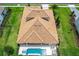 Stunning aerial view of a single-Gathering home with a tile roof, lush green grass, swimming pool, and outdoor seating at 10193 Brocksport Cir, Gotha, FL 34734