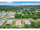 Aerial view of a residential neighborhood with lush green trees and a nearby lake at 10193 Brocksport Cir, Gotha, FL 34734