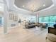 Spacious living room featuring large windows, a tray ceiling, and modern chandelier at 10193 Brocksport Cir, Gotha, FL 34734
