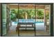 A view through sliding glass doors of the pool, patio furniture and barbecue in the outdoor kitchen at 10193 Brocksport Cir, Gotha, FL 34734