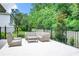 Outdoor seating area with a table and chairs in a beautiful backyard with a black fence and green foliage at 10193 Brocksport Cir, Gotha, FL 34734