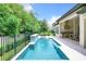 Gorgeous pool with a tiled waterfall feature, green backyard, and an outdoor kitchen with a pizza oven at 10193 Brocksport Cir, Gotha, FL 34734