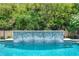 Beautiful pool with a mosaic tile water feature and lush greenery at 10193 Brocksport Cir, Gotha, FL 34734