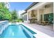 Relaxing pool area with full outdoor kitchen, waterfall feature, and plenty of room to sit and enjoy time outside at 10193 Brocksport Cir, Gotha, FL 34734