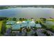Aerial view of a community clubhouse with a tennis court, pool, and a lake in the background at 2877 Attwater Loop, Winter Haven, FL 33884