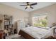 Bright bedroom with a bed, shelves, and a large window overlooking the neighborhood at 2877 Attwater Loop, Winter Haven, FL 33884