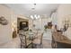 View of dining area with modern chandelier, and glass-top table, with view to kitchen and living room at 2877 Attwater Loop, Winter Haven, FL 33884
