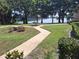 Exterior of condo buildings showing manicured lawn and walkway leading toward lake at 1181 Paseo Del Mar # D, Casselberry, FL 32707
