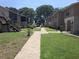 Exterior of condo buildings showing manicured lawn and walkway leading toward lake at 1181 Paseo Del Mar # D, Casselberry, FL 32707
