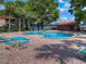 Community pool featuring blue lounge chairs and picnic tables with view of the lake at 1181 Paseo Del Mar # D, Casselberry, FL 32707