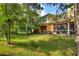 Expansive backyard featuring lush greenery, a screened lanai, and a serene wooded backdrop at 4032 Mountain Chestnut Way, Lakeland, FL 33812