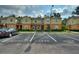 A townhome complex showing ample parking and landscaping under a partly cloudy sky at 4032 Mountain Chestnut Way, Lakeland, FL 33812