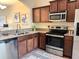 A kitchen featuring stainless steel appliances, granite countertops, and dark wood cabinets at 4032 Mountain Chestnut Way, Lakeland, FL 33812