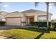 Tan house with brown trim, a double-door entry, and a neatly landscaped lawn at 313 Kensington Dr, Davenport, FL 33897