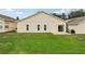 View of the backyard featuring a well-maintained lawn and the back of the home at 475 Windsor Pl, Davenport, FL 33896