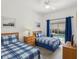 Comfortable bedroom with twin beds, wood furnishings, and sliding door access to the pool at 475 Windsor Pl, Davenport, FL 33896