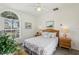 Cozy bedroom with queen bed, ceiling fan, and large arched window providing natural light at 475 Windsor Pl, Davenport, FL 33896