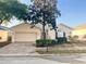 Charming single-story home featuring a brick driveway, arched window, and mature landscaping at 475 Windsor Pl, Davenport, FL 33896