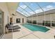 Screened-in private pool with lounge chairs and a covered patio area at 475 Windsor Pl, Davenport, FL 33896