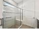 Modern bathroom shower with a glass door, built-in seat, and grab bars for accessibility and safety at 2132 Antilles Club Dr, Kissimmee, FL 34747