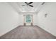 Bedroom with neutral carpet, tray ceiling, large window with blinds, and ceiling fan at 2132 Antilles Club Dr, Kissimmee, FL 34747
