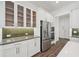 Modern kitchen with stainless steel refrigerator, wall oven, white cabinetry, and green subway tile backsplash at 2132 Antilles Club Dr, Kissimmee, FL 34747