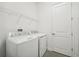 A well-equipped laundry room featuring a modern washer and dryer and a wire rack shelf at 2132 Antilles Club Dr, Kissimmee, FL 34747