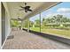 Screened patio with brick flooring, ceiling fans, and a beautiful view of the backyard and palm trees at 2132 Antilles Club Dr, Kissimmee, FL 34747