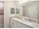 Modern bathroom featuring double sinks, granite countertops, a large mirror, and stylish fixtures at 3911 Gardenia Dr, Indian Lake Estates, FL 33855