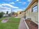 Backyard with a lush green lawn, stepping stones, and a well-maintained exterior, under a bright blue sky at 6809 Ambassador Dr, Orlando, FL 32818