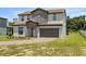 Two-story house with stone accents and landscaping at 233 Macaulay S Cv, Haines City, FL 33844