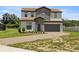Two-story house with stone accents and a paved driveway at 233 Macaulay S Cv, Haines City, FL 33844