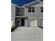 Two-story townhome with gray exterior, two-car garage, and a navy blue front door at 670 Moscato Dr, Holly Hill, FL 32117