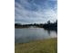 Scenic view of a lake with fountain, lush greenery, and a partly cloudy sky at 670 Moscato Dr, Holly Hill, FL 32117