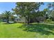Lush backyard with a well-maintained lawn, mature trees, and a screened-in patio at 404 Hightower Dr, Debary, FL 32713