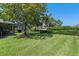 Expansive backyard with green lawn, mature trees providing shade, and manicured hedges at 404 Hightower Dr, Debary, FL 32713