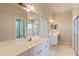 Bright bathroom featuring tile floors, dual sinks, and glass-enclosed shower at 404 Hightower Dr, Debary, FL 32713