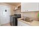 Functional laundry room with stainless steel washer, dryer, sink, and ample storage shelves at 404 Hightower Dr, Debary, FL 32713