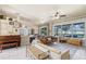 Open-concept living room featuring tile floors, ceiling fan, and large windows overlooking backyard at 404 Hightower Dr, Debary, FL 32713
