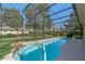Sparkling pool with a screened enclosure, waterfall feature, and lush landscaping at 404 Hightower Dr, Debary, FL 32713