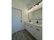 This stylish bathroom includes a double vanity, quartz counters, and modern lighting at 1102 East Pkwy, Deland, FL 32724