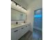 Bright bathroom featuring a double sink vanity, modern fixtures, and a walk-in shower with decorative tile at 1102 East Pkwy, Deland, FL 32724