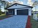 New home showcasing a stylish exterior with a dark garage door and screened-in porch at 1102 East Pkwy, Deland, FL 32724